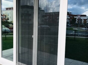 Plissé sítě proti hmyzu na bílých plastových oknech